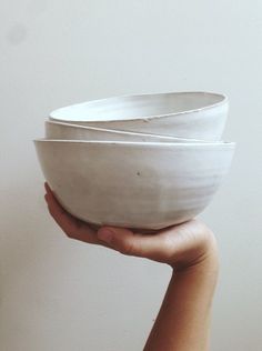 a person holding a white bowl in their left hand and the other hand is holding it up