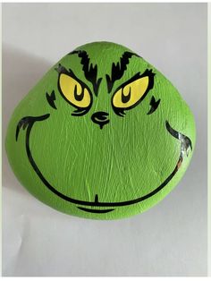 a painted rock with an angry grin face on it