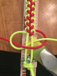 a pair of scissors are hooked up to the end of a piece of rope that is attached to a measuring ruler