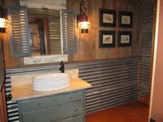 a bathroom with a sink, mirror and pictures on the wall