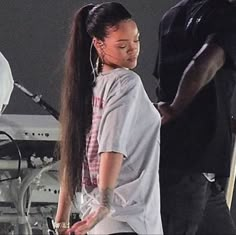 a woman with long hair standing next to a man