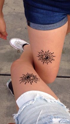 two people with tattoos on their legs and one has an eye in the middle of it