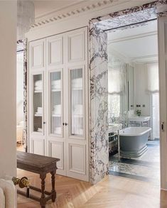 an ornate bathroom with marbled walls and flooring, along with a wooden bench