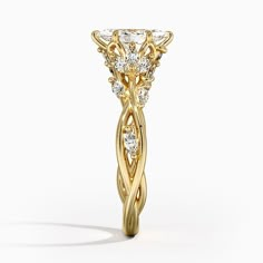 a yellow gold engagement ring with an intricate design on the side and round brilliant cut diamonds in the center