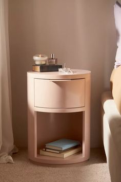 a nightstand with a book on it next to a bed