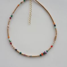 Elevate your summer style with this dainty boho beaded necklace! Handmade with colorful crystals, this small necklace is the perfect addition to your jewelry collection. Embrace the rainbow with this minimal seed bead necklace - an ideal gift for her or your bestie. Let the beach vibes shine with this delicate gold piece, perfect for summer days. Add a touch of elegance to any outfit with this stunning beaded chain gemstone necklace. Crafted with glass beads, this versatile piece is a must-have Multicolor Dainty Beads For Jewelry Making, Dainty Multicolor Beads For Jewelry Making, Gold Dainty Crystal Necklace With Colorful Beads, Dainty Crystal Necklaces For Jewelry Making With Colorful Beads, Dainty Crystal Necklace With Colorful Round Beads, Dainty Multicolor Necklaces With Spacer Beads, Dainty Colorful Beaded Necklaces For Festival, Bohemian Gold Crystal Necklace With Spacer Beads, Dainty Gold Crystal Necklace With Colorful Beads