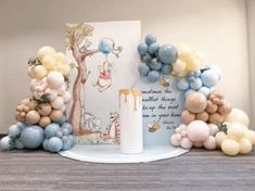 balloons and greeting cards on a table with a candle in front of the balloon arch