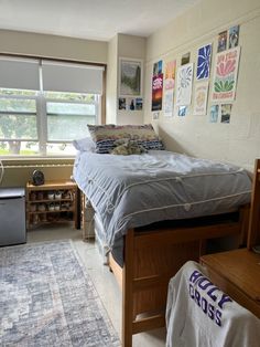 a bed room with a neatly made bed next to a window and a rug on the floor