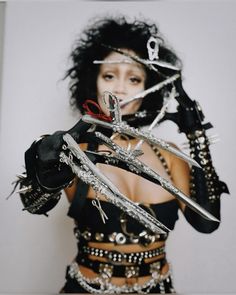 a woman with scissors and chains around her body, holding them up to the camera