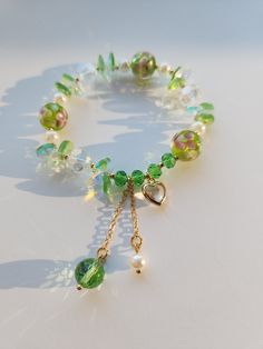 This beautiful green bracelet is very suitable for daily wear. It can also be given to girlfriends, daughters, mothers, or as a birthday gift to friends Main materials: Beads Size: My bracelets are elastic bracelets, the size of the bracelets is a little under 6.5inches without stretching, so they can be suitable for most people's wrist. It is elastic so if you need a bigger size, it is important to consider that it does stretch. Handmade Green Heart-shaped Bracelet, Bohemian Green Jewelry With Pearl Charm, Dainty Green Beaded Bracelets With Colorful Beads, Dainty Green Beaded Bracelets, Green Heart Beads Bracelet Jewelry, Green Heart Beads Bracelet, Elegant Green Charm Bracelet With Round Beads, Dainty Green Bracelets With Round Beads, Dainty Green Round Bead Bracelets