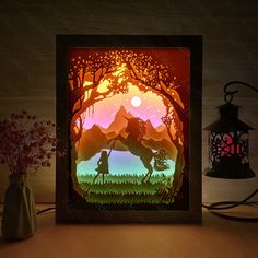 an image of a paper cut out of a man and woman in the woods at sunset