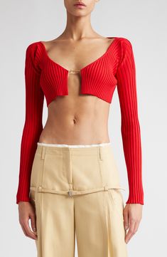 A new crop of tiny tops is taking over runways, and this ribbed cardigan version from Jacquemus steals the spotlight with a barely there fit. A delicate golden logo clasp secures the front of this sensual top with signature style. 12 1/2" Length (Size 40FR) Front clasp closure Scoop neck Long sleeves 81% Viscose, 12% Polyamide, 4% Elastane, 3% Polyester Dry clean Made in Portugal SPACE: A shop for emerging and advanced designers Ribbed Fitted Cropped Cardigan, Fitted Ribbed Cropped Cardigan, Elegant Ribbed Cropped Crop Top, Elegant Fitted Ribbed Crop Top, Red Cropped Cardigan, Tiny Tops, Golden Logo, Patent Leather Handbags, Crop Cardigan