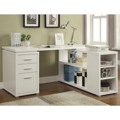 a white desk with two drawers in front of a window and pictures on the wall