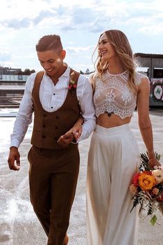 a man and woman are walking down the street holding hands while dressed in brown outfits