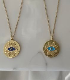 Emil, meaning energetic. Medallion gold layered evil eye pendant with dark blue enamel and a black micro pave stone. This gorgeous necklace is 20 inches long with a lobster claw clasp for ease. Polished finish. 14k yellow gold layered deep blue enamel evil eye pendant Black micro pave 20” chain Eye Motif, Eye Pendant, Evil Eye Pendant, Themed Jewelry, Evil Eye Necklace, Eye Art, Eye Necklace, Gorgeous Necklaces, Micro Pave