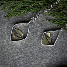 This Mixed Metal Mountain Ridge Necklace is a timelessly classic piece crafted with artisanal precision. Its solid brass mountain ridges are framed in sterling silver geometric shapes, hand-forged from sheet and wire by an artisan metalsmith. A luxurious yet understated accessory - perfect for any occasion. Nature-inspired Sterling Silver Jewelry With Polished Finish, Silver Nature-inspired Jewelry, Silver Brass Necklace With Square Pendant, Hand-forged Brass Necklace In Silver, Gift Jewelry With Polished Diamond-shaped Finish, Hand Forged Square Pendant In Sterling Silver, Elegant Silver Electroformed Jewelry, Elegant Electroformed Sterling Silver Necklace, Nature-inspired Silver Brass Necklaces