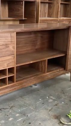 a man standing next to a large wooden desk with drawers and shelves on top of it