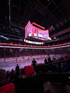 an ice hockey game is being played at the arena with people sitting in seats watching