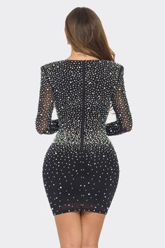 a woman in a short black dress with sheer sleeves and sequins on the back