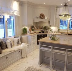 a kitchen filled with lots of counter space and white cabinets next to a breakfast nook