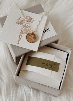 two personalized items are in a box on a white furnishing area, one is gold and the other is silver