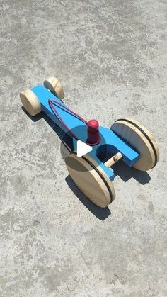 a wooden toy car sitting on top of cement