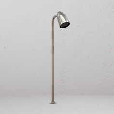 a lamp that is sitting on top of a table in front of a white wall