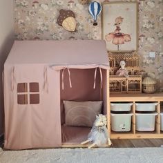 a dog sitting in front of a doll house