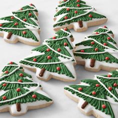 decorated christmas tree cookies on a white surface