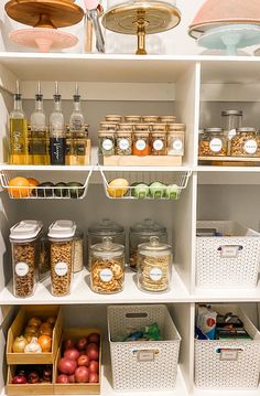 an organized pantry filled with lots of food and condiments, including apples, oranges