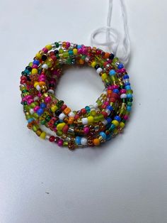 Brighten your life and wardrobe with our stunning Multicolored Waistbead. Handcrafted with love, each bead is carefully selected and strung to create a vibrant, eye-catching accessory that complements any outfit. Uses of the Multicolored Waistbead: • Fashion Statement: Wear it over or under your clothing to add a pop of color and a touch of elegance to your ensemble. • Body Awareness: Helps you stay mindful of your body, serving as a gentle reminder of your fitness and wellness journey. • Weight Adjustable Beaded Chain Beads For Festive Occasions, Adjustable Beaded Chain For Festive Occasions, Festive Colorful Beaded Bracelets, Festive Green Beaded Bracelets, Festive Colorful Beads Bracelet, Festive Green Beaded Bracelets With Colorful Beads, Multicolor Beaded Round Beads Jewelry, Multicolor Bohemian Beaded Bracelets For Festive Occasions, Multicolor Bohemian Beaded Bracelet For Festive Occasions