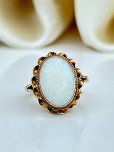 Vintage 9ct Yellow Gold Large Cabochon Opal Ring  Truly beautiful fiery opal with spilt shoulders  The item comes without the box in the photo but will be presented in a Gembank1973 gift box Measurements: weight 3.72g, size UK M US 61/2, head of ring 17mm x 14mm, height off finger 7mm Materials: 9ct yellow gold and Opal   Hallmarks: stamped 9.375 Condition: The overall condition is very good Office use: USZ Luxury Heirloom Cabochon Opal Ring, Formal Hallmarked Oval Cabochon Opal Ring, Vintage White Opal Ring For Formal Occasions, Classic Cabochon Opal Ring Gift, Classic Cabochon Opal Ring As Gift, Victorian Cabochon Opal Ring For Gift, Victorian Opal Cabochon Ring As Gift, Victorian Gold Opal Ring Gift, Victorian Style Cabochon Opal Ring Gift