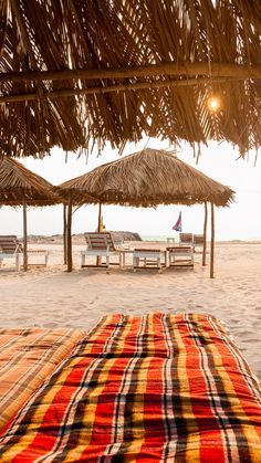 the beach is covered with straw umbrellas and chairs