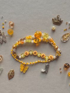 several bracelets with beads and charms on top of a gray surface, including one bead