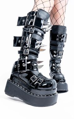 The BEAR-215s are the ideal boots for any buckles-and-claws fan - and really, who doesn't want 'em? 4 1/2 inch (114mm) platform. Vegan black leather and black patent. Tiered pyramid stud trimmed platforms. Metal claw spikes Multi size buckle strap closure. Inside metal zip closure. U.S. women's sizing-please refer to the size chart for more info. Black Grunge Platform Boots With Spikes, High-top Platform Emo Boots, Gothic Black Spiked Platform Boots, Black High-top Spiked Platform Boots, Grunge High-top Platform Boots With Spikes, Goth Roller Skates, Boots Ideas, Demonia Boots, Goth Boots