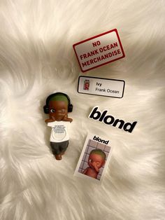 there is a small doll with headphones on next to a sign that says no frank ocean merchandise