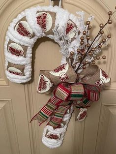 a christmas wreath on the front door decorated with candy canes and burlocks