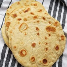 three pita breads sitting on top of a black and white towel