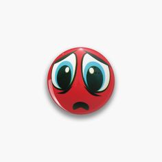 a red button with blue eyes and an angry look on it's face, against a white background