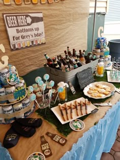 a table topped with lots of desserts and drinks next to a sign that says beer here