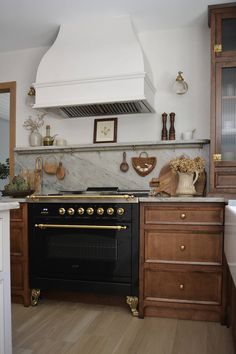 a stove top oven sitting inside of a kitchen next to a wooden cabinet and counter