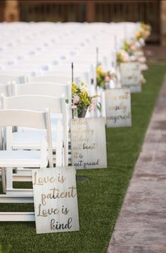 rows of white chairs with wooden signs that say love is patient and it does not envy