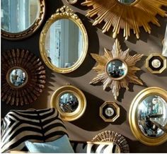 many mirrors are arranged on the wall with gold trimmings and starburst designs