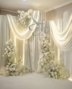 an elegant wedding setup with white flowers and drapes