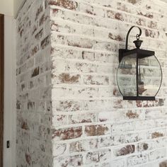 a brick wall with a lantern hanging on it