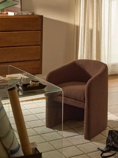 a brown chair sitting next to a glass table