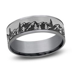 a wedding band with mountains and trees engraved on it