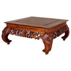 a wooden coffee table with carved carvings on the top and bottom, sitting against a white background