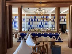 the interior of a restaurant with blue and white tiles on the walls, wooden tables and chairs