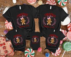 three christmas t - shirts sitting on top of a table next to candy canes